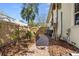 Side yard brick path with tropical plants and a wooden fence for privacy at 235 Aberdeen St, Dunedin, FL 34698