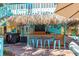 Outdoor tiki bar featuring a thatched roof, outdoor grill and seating at 235 Aberdeen St, Dunedin, FL 34698