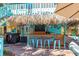 Outdoor tiki bar featuring bamboo accents, seating, and entertainment options for relaxed backyard gatherings at 235 Aberdeen St, Dunedin, FL 34698