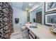 Well-lit bathroom with a framed mirror, patterned shower curtain, and white tile floors at 2749 Countryside Blvd # 28, Clearwater, FL 33761