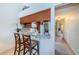 Bright kitchen featuring a granite countertop breakfast bar, stainless steel appliances, and adjacent hallway at 2749 Countryside Blvd # 28, Clearwater, FL 33761