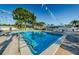 Beautiful community swimming pool with pristine water, surrounded by lush landscaping and lounge chairs at 2749 Countryside Blvd # 28, Clearwater, FL 33761