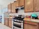 Spacious kitchen featuring wood cabinets and modern stainless steel gas range at 31818 Blythewood Way, Wesley Chapel, FL 33543