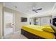 Bright bedroom featuring a ceiling fan, flatscreen TV, access to living room and a large bed with built in storage at 36750 Us Highway 19 N # 3-210, Palm Harbor, FL 34684