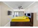 Comfortable bedroom with a platform bed with storage, ceiling fan, and a TV on the wall at 36750 Us Highway 19 N # 3-210, Palm Harbor, FL 34684