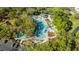 Aerial view of the community pool with plenty of lounge chairs, umbrellas, and a poolside restaurant at 36750 Us Highway 19 N # 3-210, Palm Harbor, FL 34684