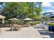 Charming outdoor dining area with tables, chairs, umbrellas, and views of the surrounding landscape at 36750 Us Highway 19 N # 3-210, Palm Harbor, FL 34684