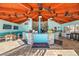 Pool bar with ample seating, TV, and tiled floor under an orange wood ceiling with ceiling fans at 36750 Us Highway 19 N # 3-210, Palm Harbor, FL 34684