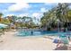 Resort-style pool with waterfall, area and lounge chairs surrounded by lush tropical landscaping in a sunny day at 36750 Us Highway 19 N # 3-210, Palm Harbor, FL 34684
