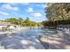 Expansive pool area featuring a waterfall, gazebo, lounge chairs and lush landscaping under a sunny, partly cloudy sky at 36750 Us Highway 19 N # 3-210, Palm Harbor, FL 34684