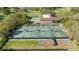 Aerial view of tennis courts and the building surrounded by green landscaping and golf course on a partly sunny day at 36750 Us Highway 19 N # 3-210, Palm Harbor, FL 34684