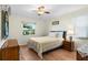 Comfortable bedroom with hardwood floors, a ceiling fan, and a window providing natural light and a pleasant view at 407 Feltham Trl # A, Sun City Center, FL 33573