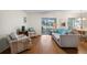 Bright living room with hardwood floors, neutral paint, access to the dining area and lanai, and comfortable seating at 407 Feltham Trl # A, Sun City Center, FL 33573