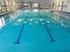 A beautiful indoor swimming pool with clear water and marked lanes, perfect for exercise and relaxation at 407 Feltham Trl # A, Sun City Center, FL 33573