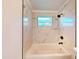 Modern bathroom featuring a bathtub and shower with marble-patterned tile and black fixtures at 4586 12Th N Ave, St Petersburg, FL 33713
