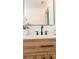 Close up of neutral toned bathroom with marble tile, modern sink with dark fixtures and decorative mirror at 4586 12Th N Ave, St Petersburg, FL 33713