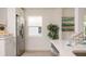 Modern kitchen with stainless steel fridge, white cabinets and countertops, alongside a window at 4586 12Th N Ave, St Petersburg, FL 33713