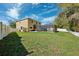 Expansive backyard with lush lawn, white fence, and screened pool area, perfect for outdoor entertaining at 4821 Barchetta Dr, Land O Lakes, FL 34639