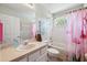 Charming bathroom with flamingo-themed shower curtain, a bathtub, and a vanity with ample counter space at 4821 Barchetta Dr, Land O Lakes, FL 34639