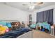 Well-lit bedroom with colorful decor, a white bed frame, blue desk, and carpet flooring, offering a playful space at 4821 Barchetta Dr, Land O Lakes, FL 34639