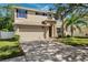Two story home featuring a two car garage, neutral paint, dark shutters, landscaped yard and mature trees at 4821 Barchetta Dr, Land O Lakes, FL 34639