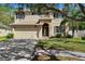 Two story home featuring a two car garage, neutral paint, dark shutters, landscaped yard and mature trees at 4821 Barchetta Dr, Land O Lakes, FL 34639