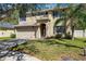 Two story home featuring a two car garage, neutral paint, dark shutters, landscaped yard and mature trees at 4821 Barchetta Dr, Land O Lakes, FL 34639