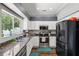 Bright kitchen featuring stainless appliances, dark counters, and views of the backyard at 4821 Barchetta Dr, Land O Lakes, FL 34639