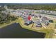 Aerial view of a house near a tranquil lake featuring a screened-in patio and well-maintained landscaping at 4904 Eagle Rock Dr, Wimauma, FL 33598