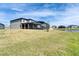 A side view showcases a spacious backyard with a screened patio and a view of the adjacent lake at 4904 Eagle Rock Dr, Wimauma, FL 33598