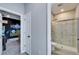 View of the bathroom and doorway of bedroom, showcasing a seamless glass shower and tile flooring at 4904 Eagle Rock Dr, Wimauma, FL 33598