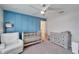 Stylish bedroom featuring a crib, changing table, and a lovely blue paneled wall at 4904 Eagle Rock Dr, Wimauma, FL 33598