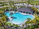 A large, resort-style community pool, complete with palm trees, lounge chairs, and a covered cabana area at 4904 Eagle Rock Dr, Wimauma, FL 33598