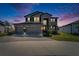Beautiful two-story home featuring a three-car garage, stone accents, and manicured landscaping at 4904 Eagle Rock Dr, Wimauma, FL 33598