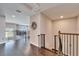 Bright hallway with wood floors featuring decorative wreath and black metal stair railing at 4904 Eagle Rock Dr, Wimauma, FL 33598
