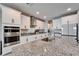 Close up on kitchen island featuring white cabinets, stainless steel appliances, and granite countertops at 4904 Eagle Rock Dr, Wimauma, FL 33598