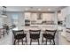 Kitchen island with stainless appliances, white cabinets, granite countertops, and barstool seating in open floorplan at 4904 Eagle Rock Dr, Wimauma, FL 33598