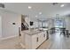 Kitchen island and open floorplan featuring white cabinets, granite countertops, stainless appliances, and wood-look tile at 4904 Eagle Rock Dr, Wimauma, FL 33598
