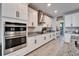 Kitchen featuring white cabinets, stainless steel appliances, granite countertops, and a tile backsplash at 4904 Eagle Rock Dr, Wimauma, FL 33598