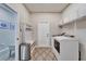 Well-organized laundry room with ample storage, a built-in bench, and modern washer and dryer units at 4904 Eagle Rock Dr, Wimauma, FL 33598