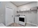 Functional laundry room featuring modern appliances, storage shelves, and stylish flooring at 4904 Eagle Rock Dr, Wimauma, FL 33598