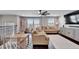 Bright living room with large windows, stylish furniture, and dark wood flooring at 4904 Eagle Rock Dr, Wimauma, FL 33598