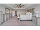 Spacious bedroom featuring a tray ceiling, ceiling fan, sitting bench, and matching dressers and nightstands at 4904 Eagle Rock Dr, Wimauma, FL 33598