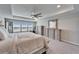 Relaxing bedroom with tray ceiling featuring sitting area and a view of the community pond at 4904 Eagle Rock Dr, Wimauma, FL 33598