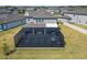 An aerial view shows a large screened-in patio with dining and seating areas, offering outdoor living space at 4904 Eagle Rock Dr, Wimauma, FL 33598