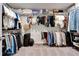 Spacious walk-in closet features multiple tiers of shelving and hanging rods for ample storage at 4904 Eagle Rock Dr, Wimauma, FL 33598