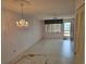 Empty living room featuring vintage chandelier and ceiling fan ready for decorating and new flooring at 5095 Bay Ne St # 310, St Petersburg, FL 33703