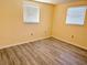 Neutral-walled bedroom with gray floors has two windows with blinds, and a ceiling-mounted light fixture at 5239 Drift Tide Dr, New Port Richey, FL 34652