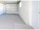 Spacious garage with a gray floor and a white door and walls at 5712 Mallow St, New Port Richey, FL 34652