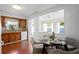 Cozy dining area adjacent to kitchen featuring hardwood floors, table set for four, and light from kitchen window at 5713 23Rd S Ave, Gulfport, FL 33707